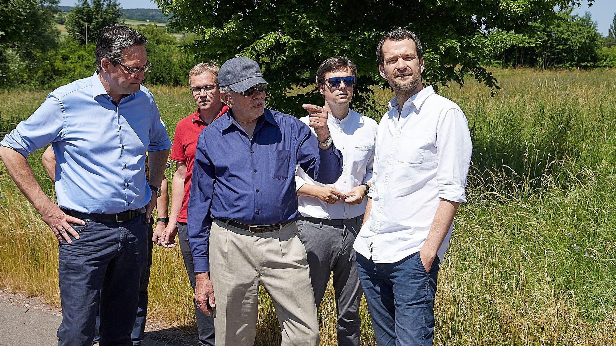 Die Besuchergruppe und der Schevener Ortsvorsteher in einem Bereich am Ortsrand von Scheven.