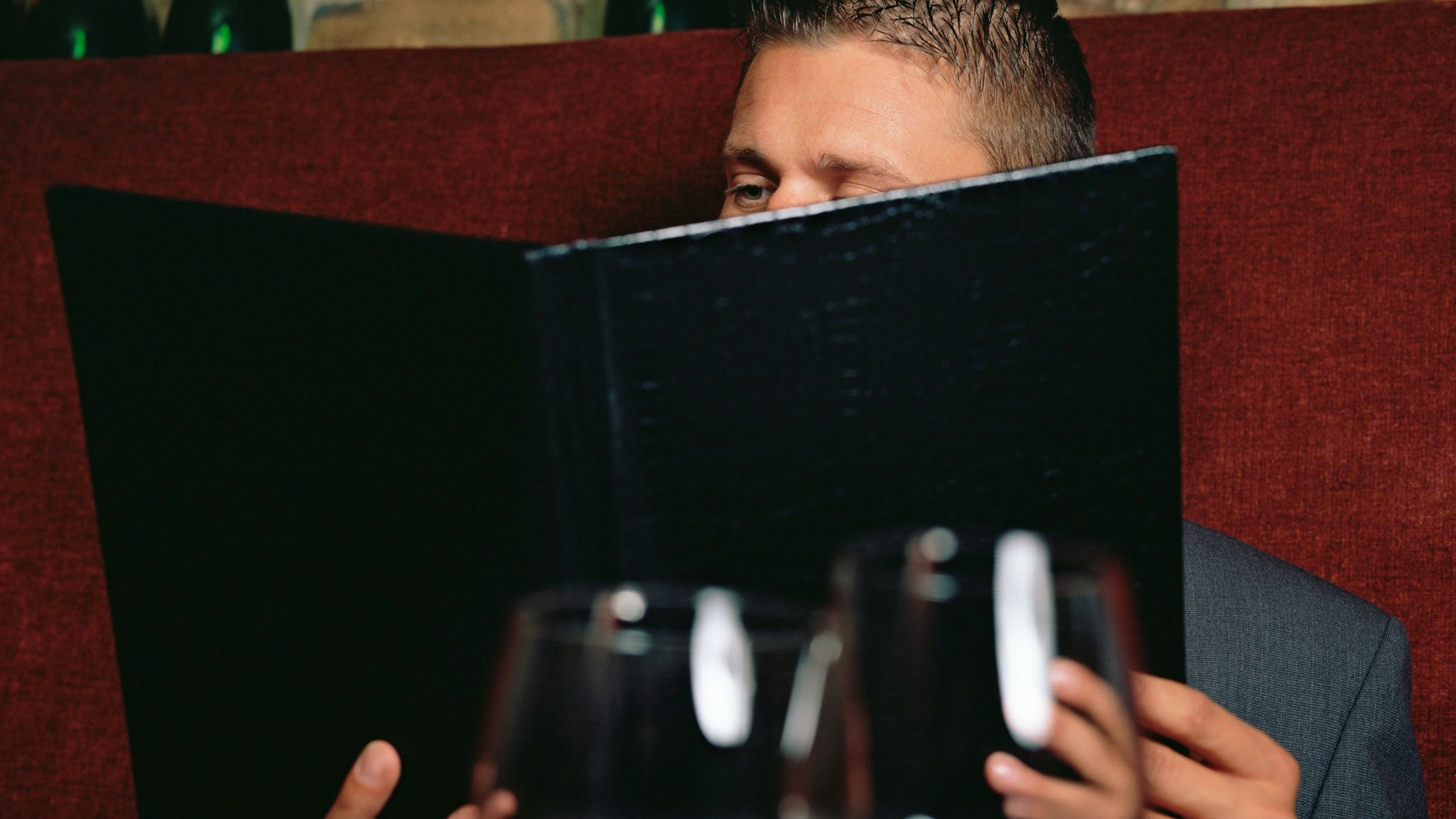 Mann liest die Weinkarte im Restaurant