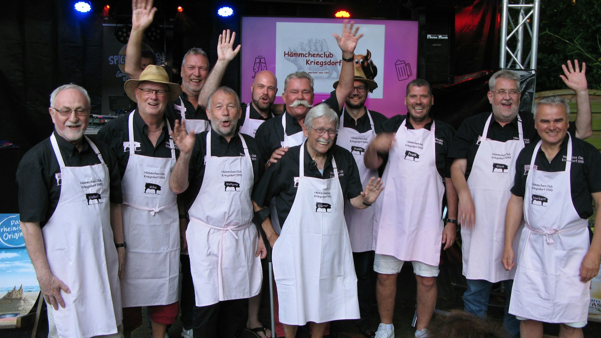 Männer mit Schürzen jubeln.