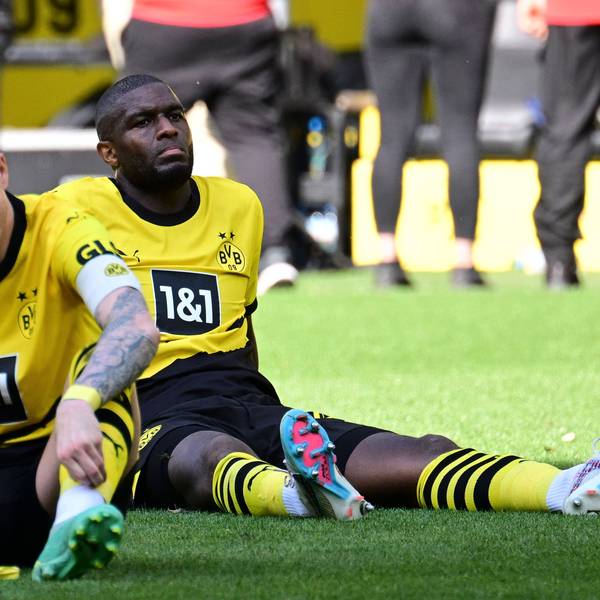 Anthony Modeste sitzt im BVB-Trikot auf dem Rasen.