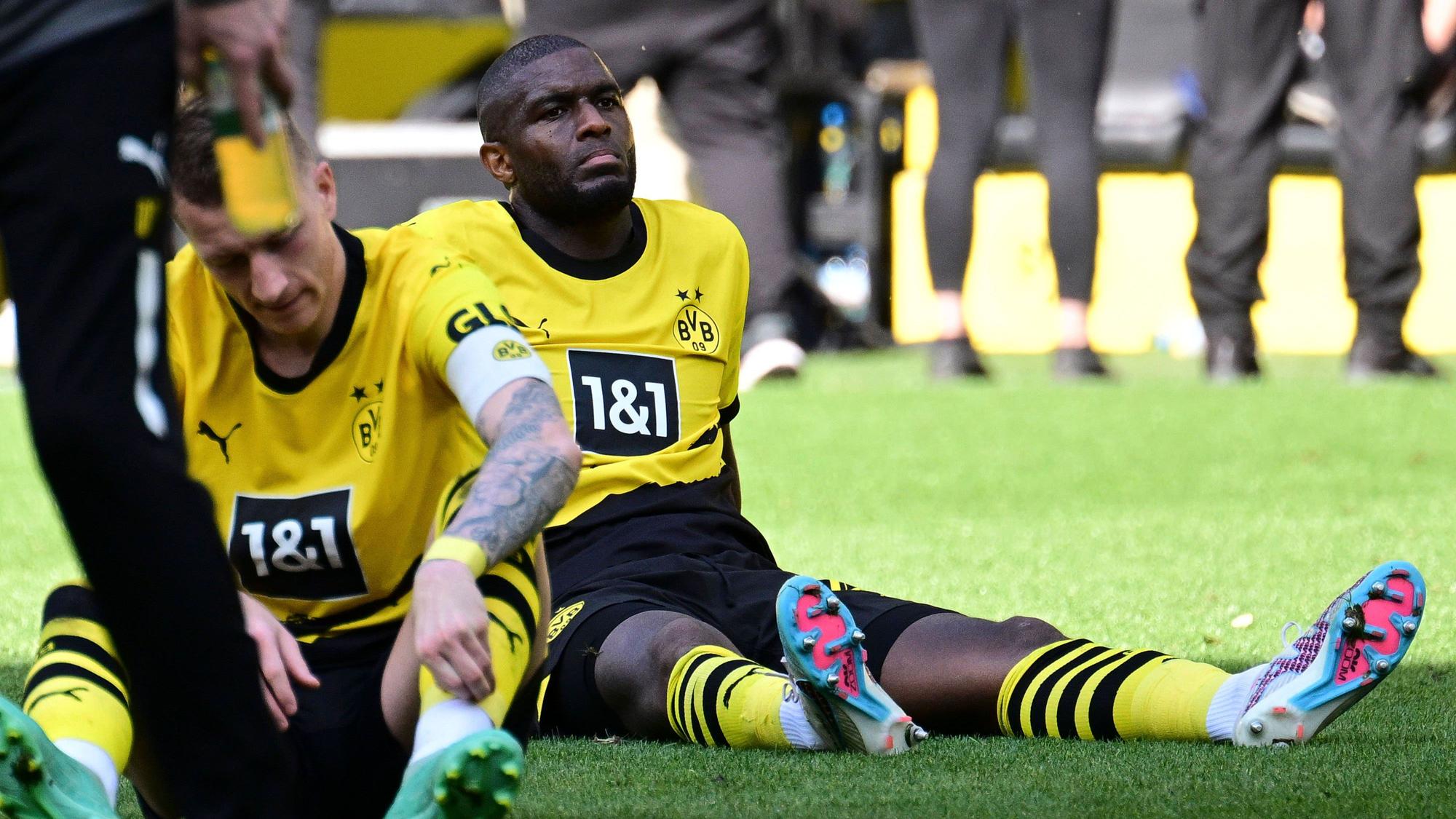 Anthony Modeste sitzt im BVB-Trikot auf dem Rasen.