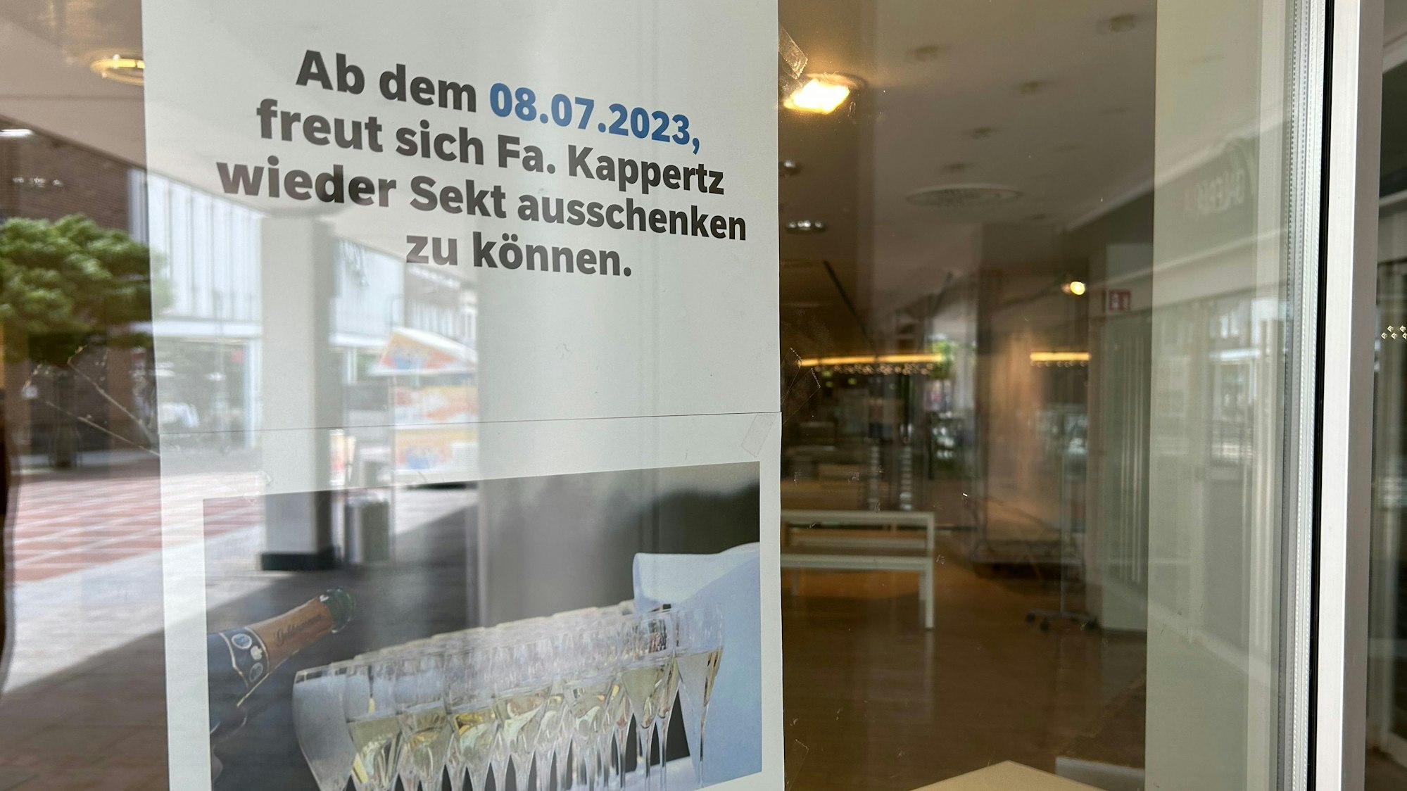 Ein Zettel informiert über die Rückkehr eines Sektstandes vor die Kaufhaus-Filiale.