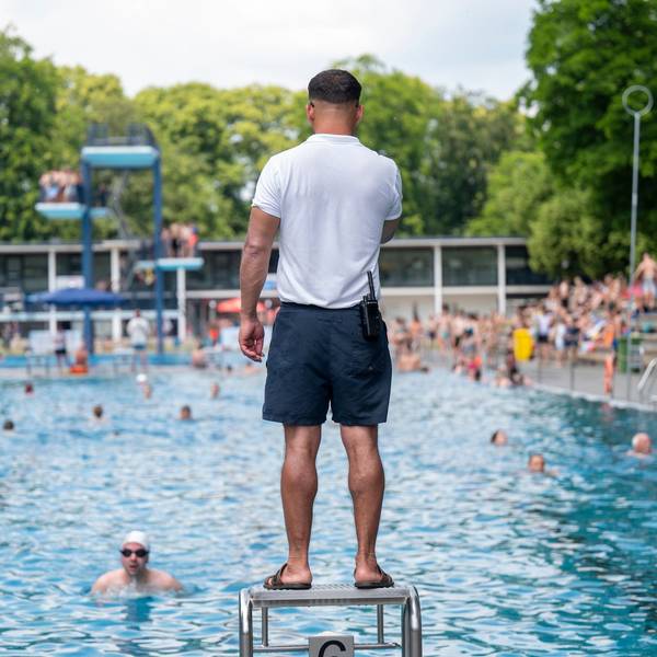 Ein Bademeister steht am Beckenrand des Stadionbads.