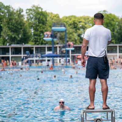 Ein Bademeister steht am Beckenrand des Stadionbads.