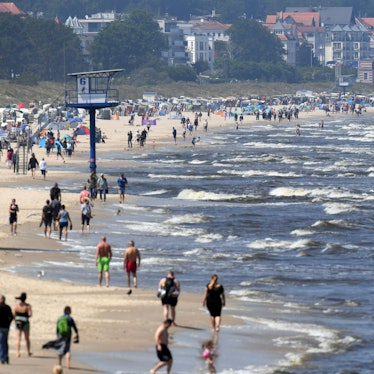 ARCHIV - 13.06.2020, Mecklenburg-Vorpommern, Heringsdorf: Touristen spazieren am Strand an der Ostsee auf der Insel Usedom entlang. Millionen Urlauber in Deutschland fahren jedes Jahr ans Meer. Doch Küste ist nicht gleich Küste. Wer es mild und romantisch mag, bevorzugt die Ostsee. Wilder und rauer geht es hingegen an der Nordsee zu. (zu dpa "Nordsee vs. Ostsee - Was Urlauber an die Küsten zieht") Foto: Stefan Sauer/dpa-Zentralbild/dpa +++ dpa-Bildfunk +++