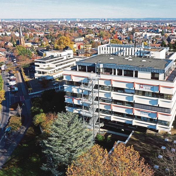 Eine Luftaufnahme vom Caritas Seniorenzentrum in Hürth-Hermülheim, um das Gebäude stehen Bäume.