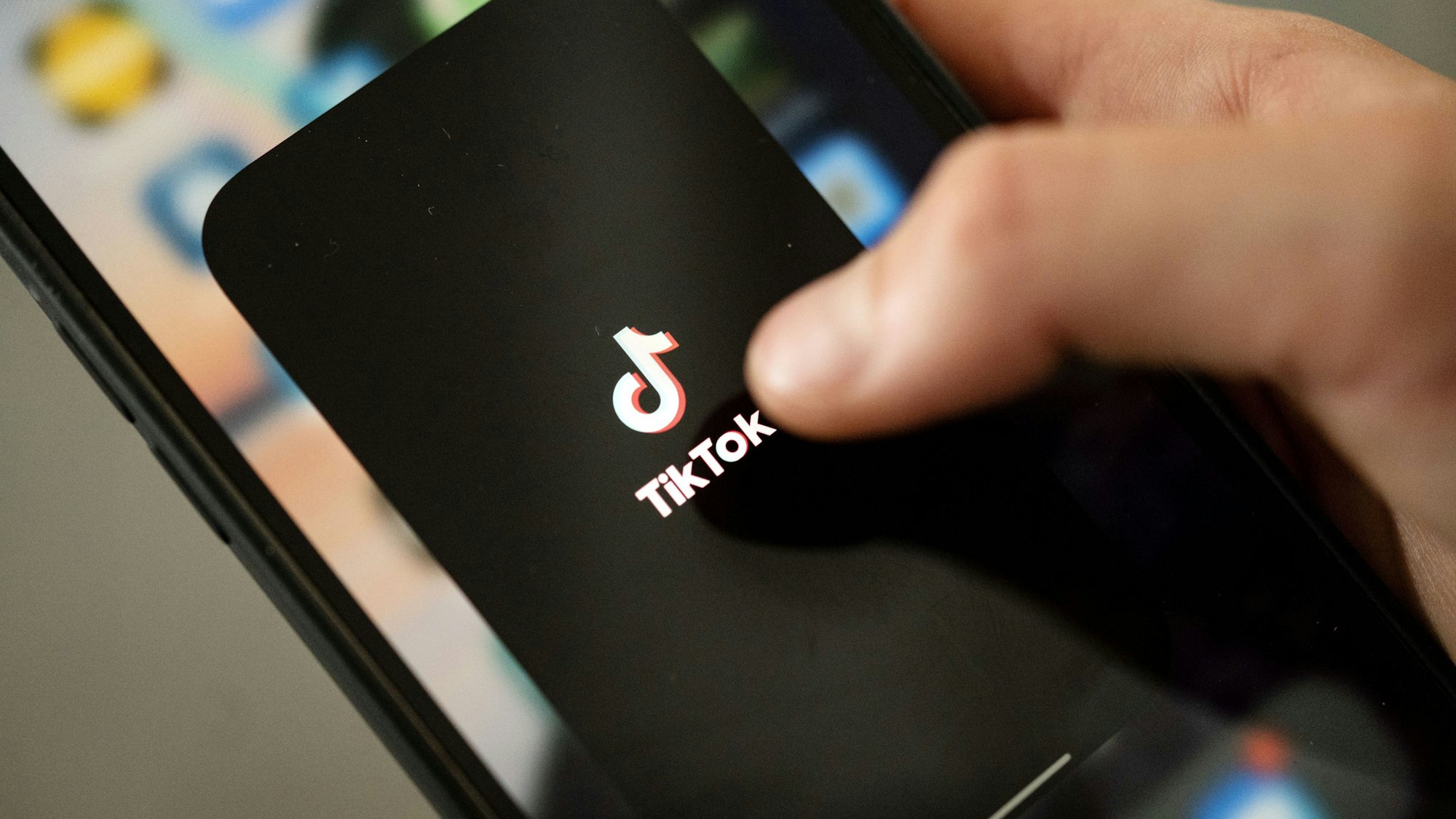 Eine Person tippt auf das TikTok-Logo auf einem Smartphone. Das bekannte Netzwerk startet offenbar einen eigenen Musik-Streamingdienst. (Symbolbild)