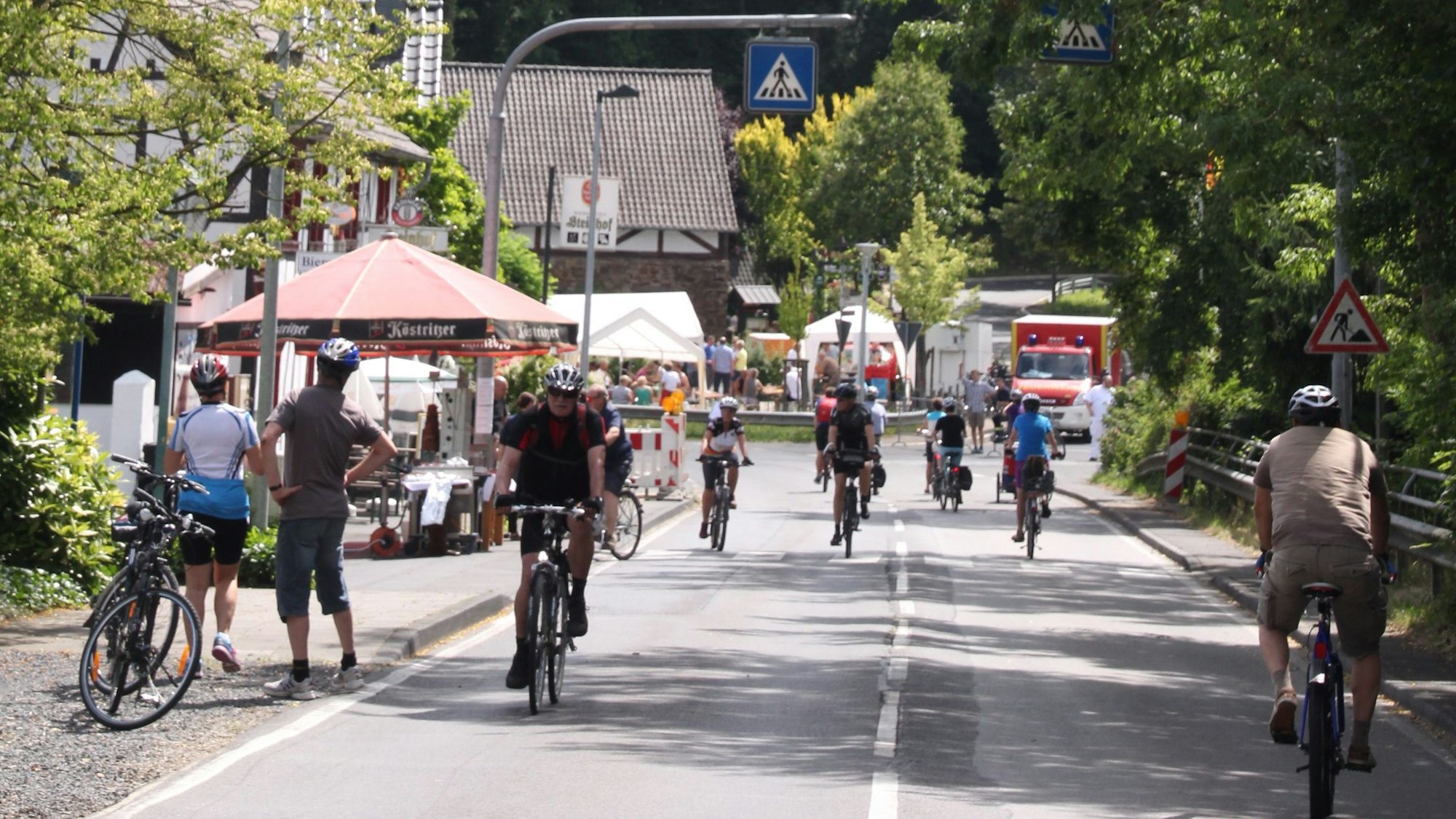 Mehrere Fahrradfahrer fahren auf einer für Autos gesperrten Straße.