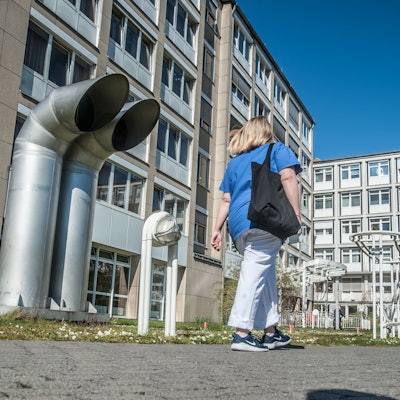 Eine Frau geht auf den Eingang des Klinikums Leverkusen zu.