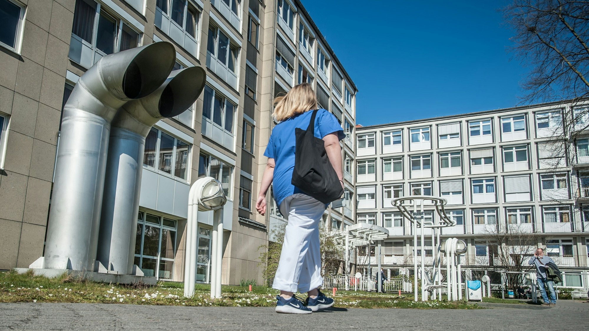 Eine Frau geht auf den Eingang des Klinikums Leverkusen zu.