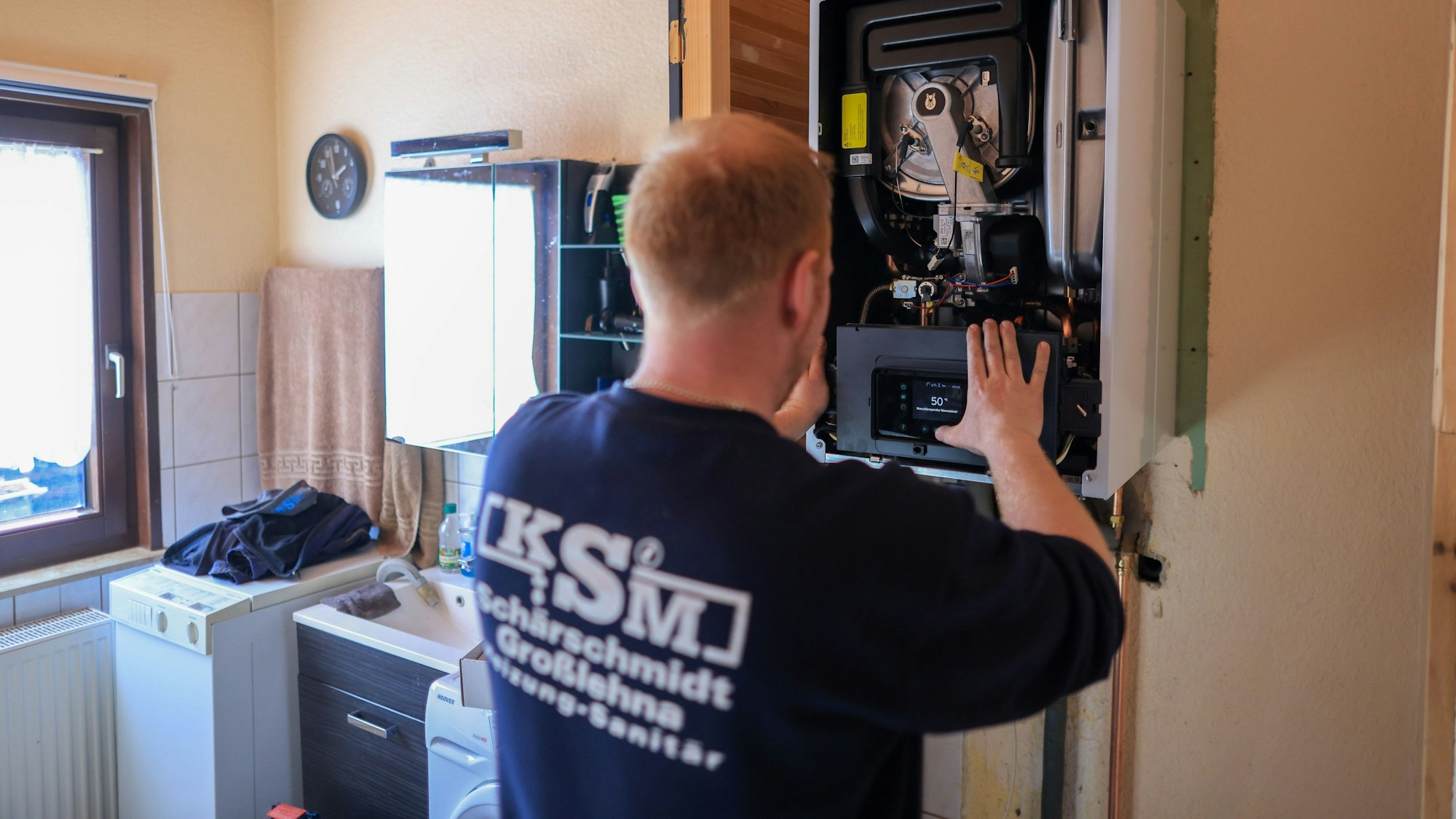 ARCHIV - 01.03.2023, Sachsen, Markranstädt: Ein Mitarbeiter einer Sanitär- und Heizungsbaufirma installiert eine moderne Gasbrennwerttherme in einem Einfamilienhaus. Habeck lehnt bei der Wärmewende einen zu starken Fokus auf Wasserstoff ab. (zu dpa «Habeck: Keine «leeren Versprechen» zum Heizen mit Wasserstoff machen») Foto: Jan Woitas/dpa +++ dpa-Bildfunk +++