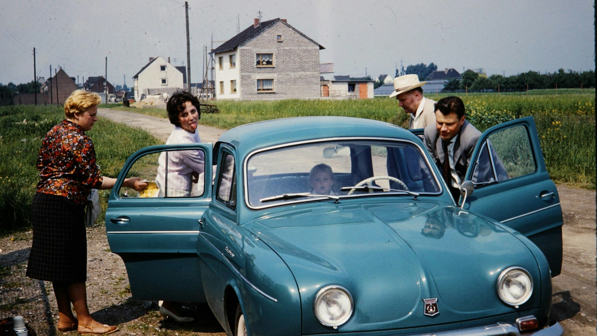 Eine Familie besucht mit dem eigenen Wagen ihre Verwandtschaft im Stadtteil Menden im Jahr 1961.