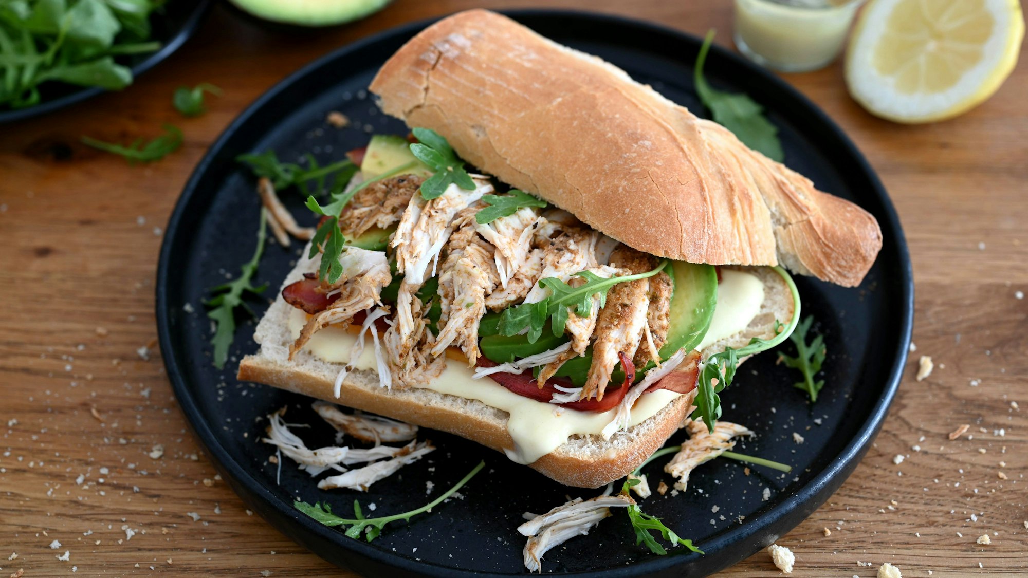 Das Hähnchen fürs Ciabatta wird mariniert, gegrillt, gezupft und dann zwischen Cheddar, Bacon, Avocado und Rucola gestapelt.