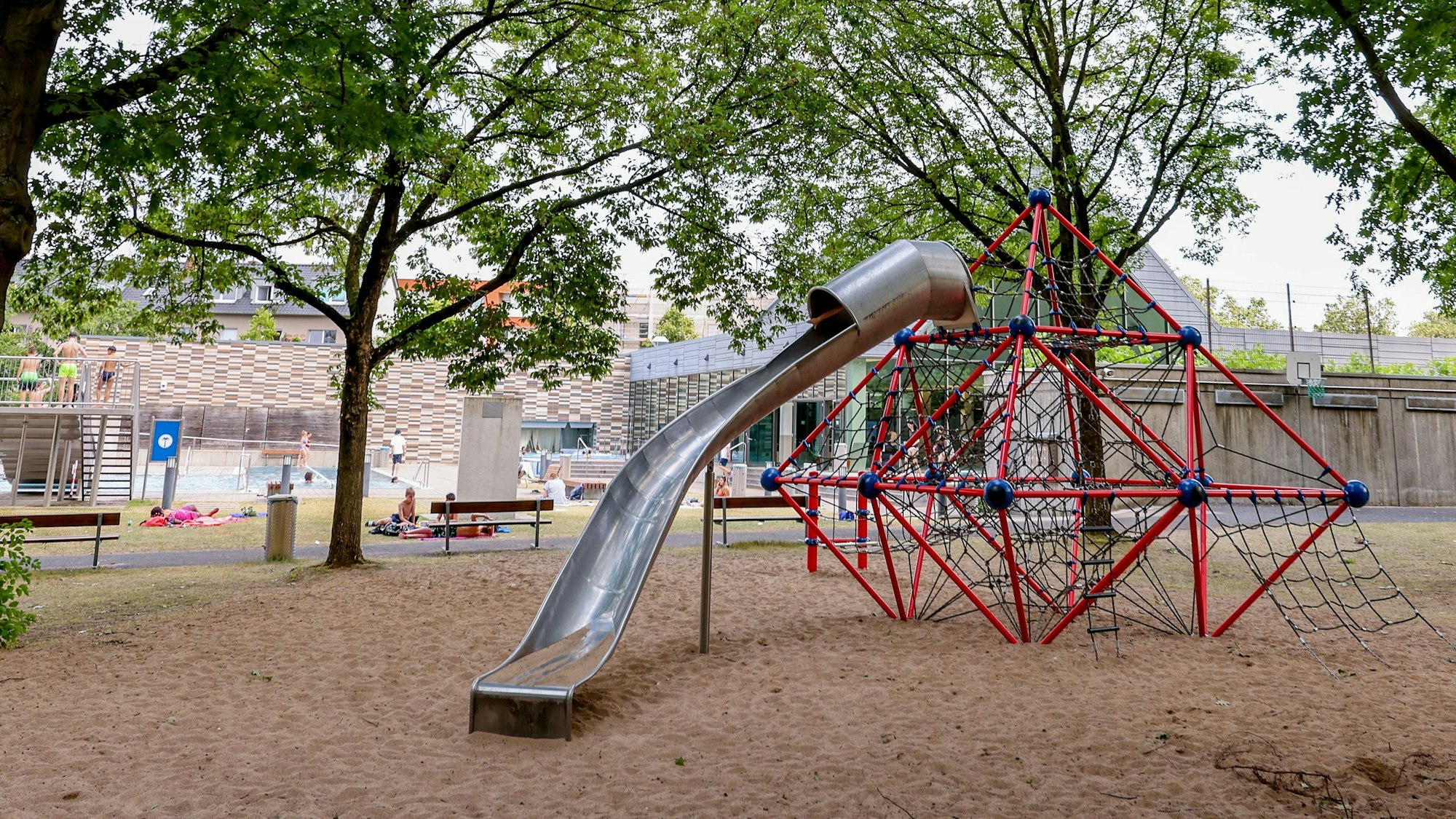 Auf dem Gelände des Zollstockbades steht ein rotes Klettergerüst mit Rutsche.