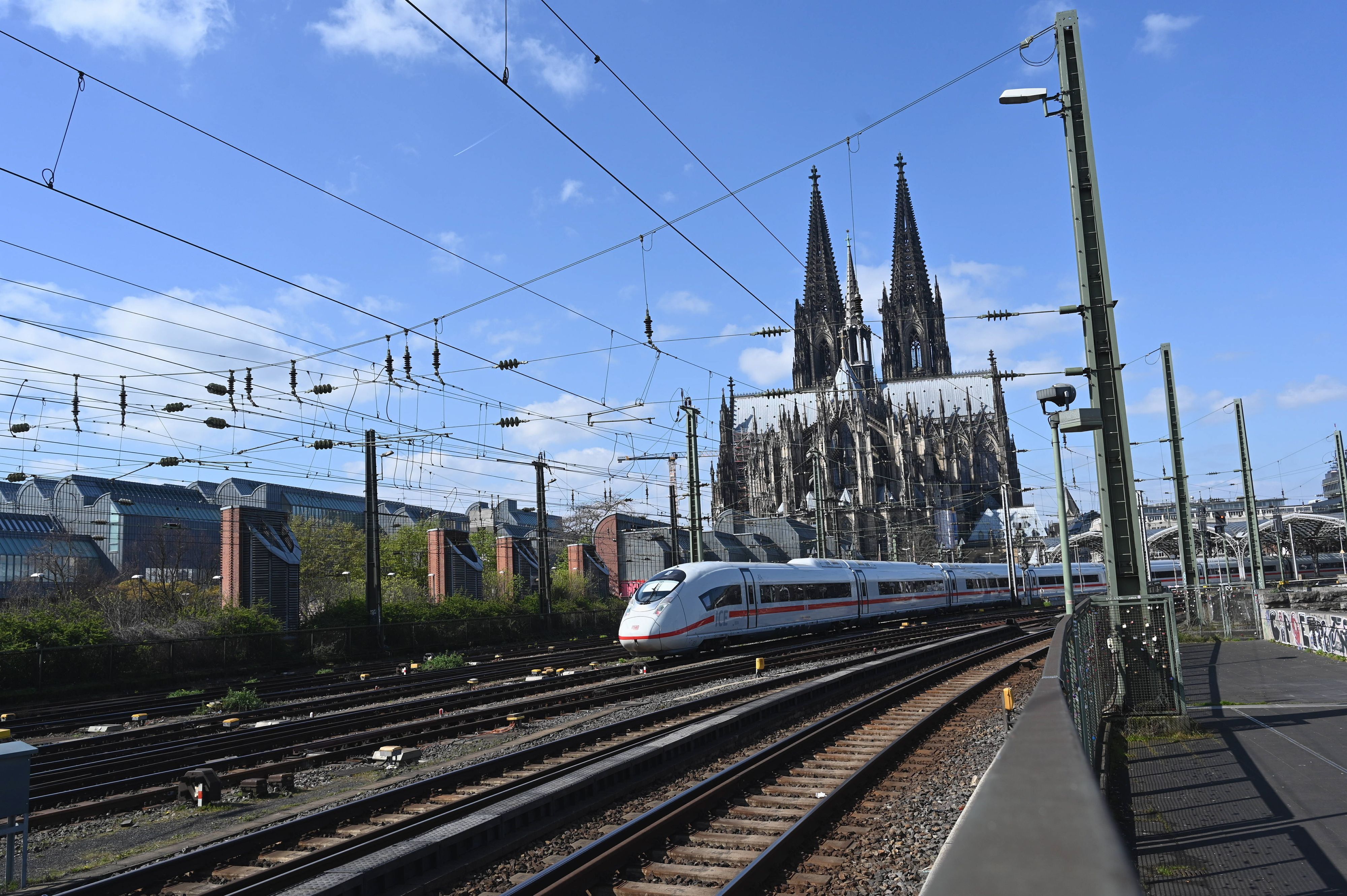 Die Einfahrt zum Kölner Hauptbahnhof mit einem ICE ICE3 Neo auf den Gleisen und dem Kölner Dom.