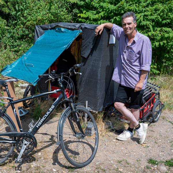 Sven Peters lehnt sich an seinen Radanhänger.