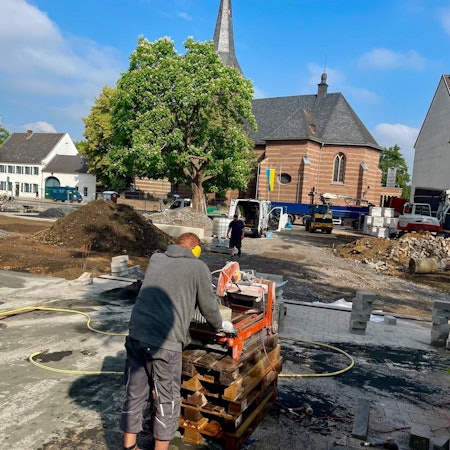 Arbeiter tragen Kies und Sand auf während der Bauarbeiten am Carl-Schurz-Platz