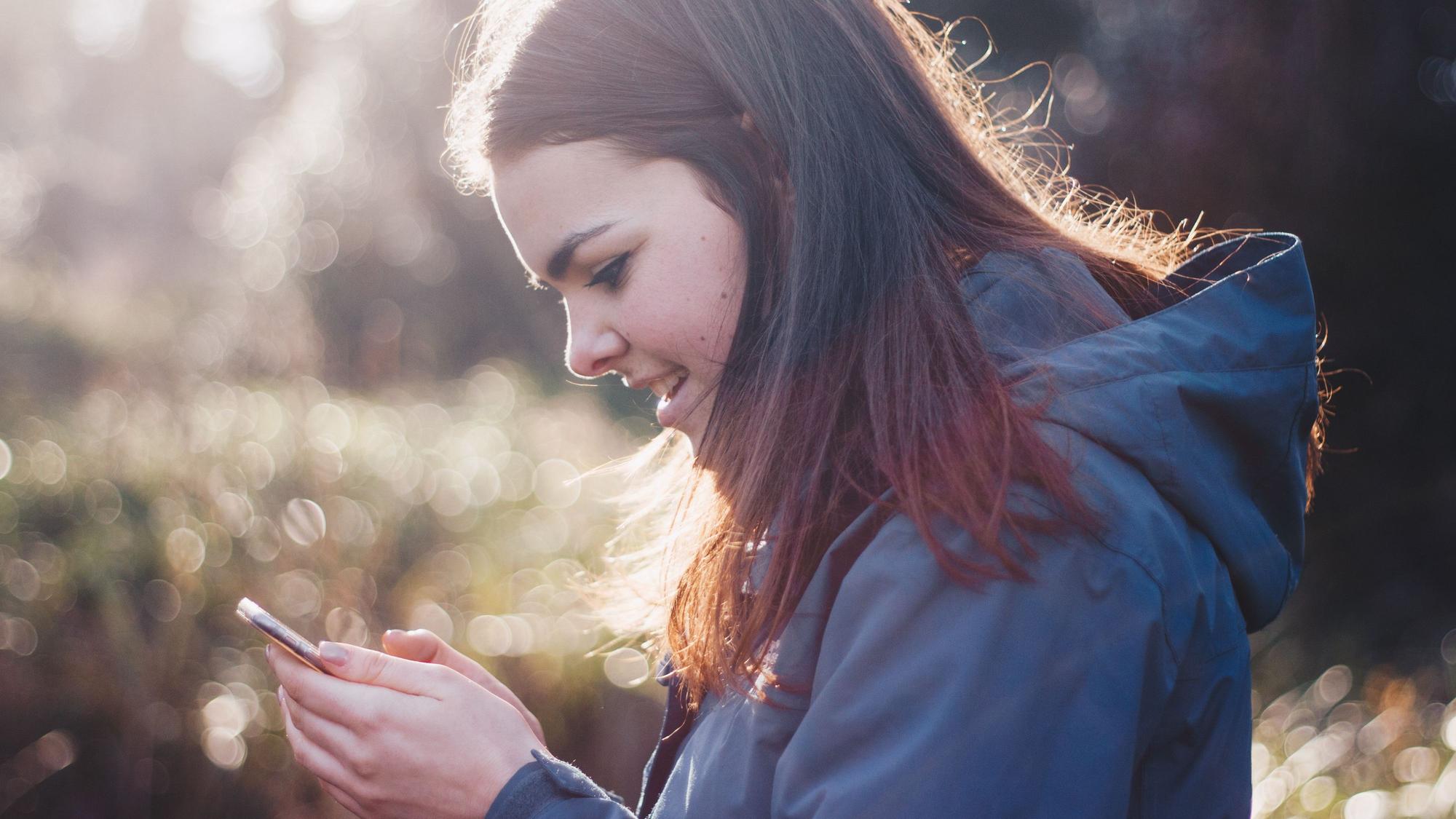 Ein Mädchen schaut auf ein Smartphone
