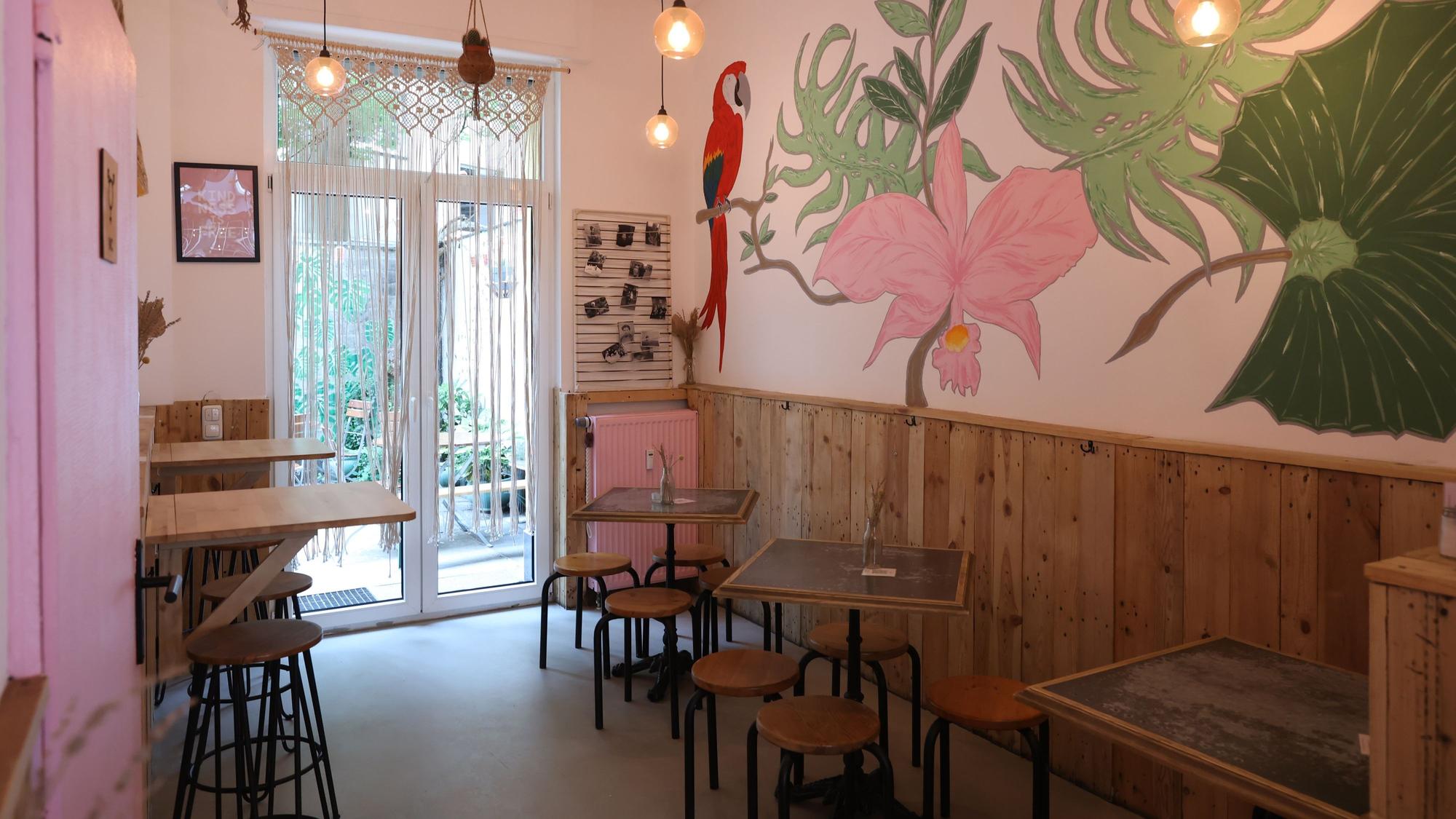 Der Innenraum eines Restaurants, an der Wand ein Bild mit Blumen und einem Papagei