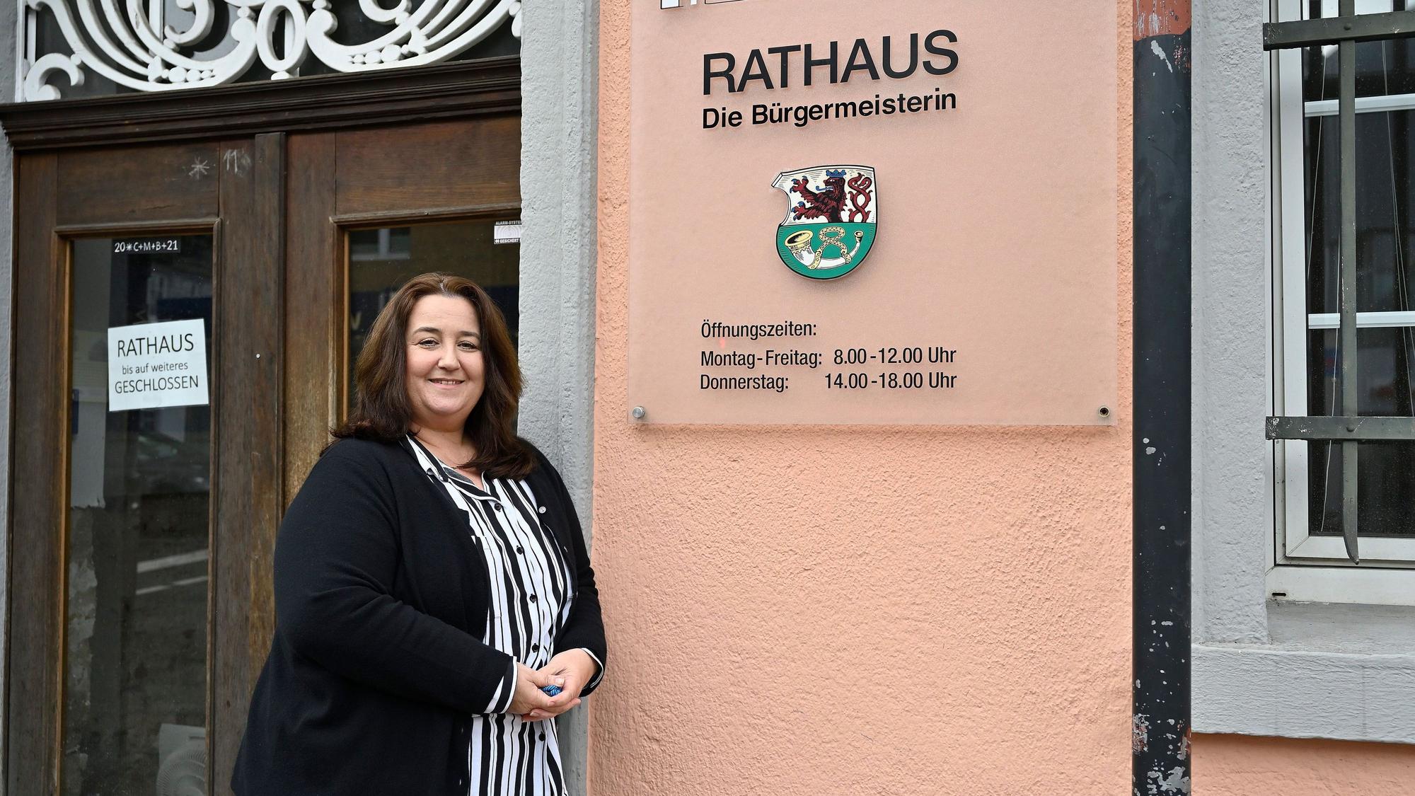 Bondina Schulze steht vor einem Rathausschild.