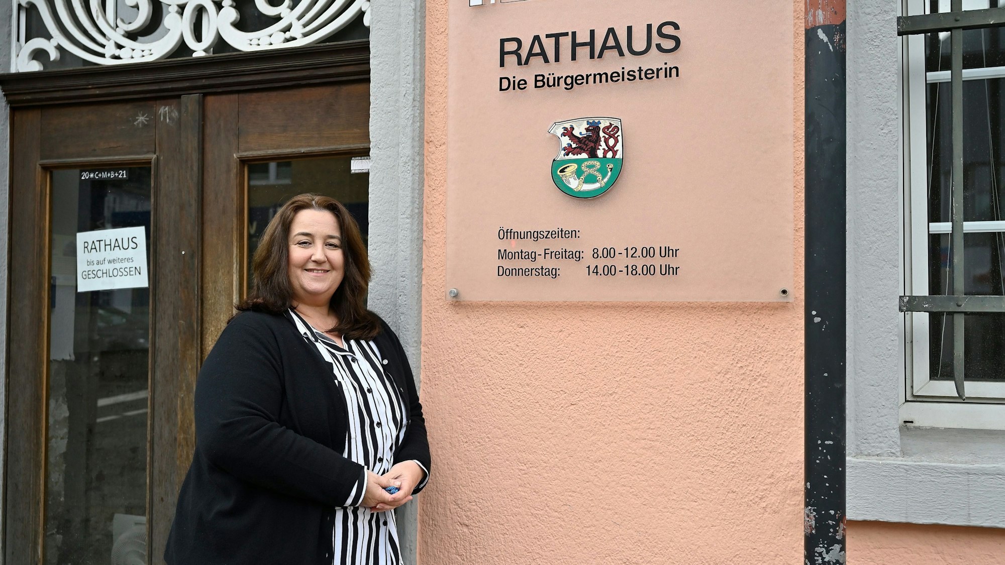 Bondina Schulze steht vor einem Rathausschild.
