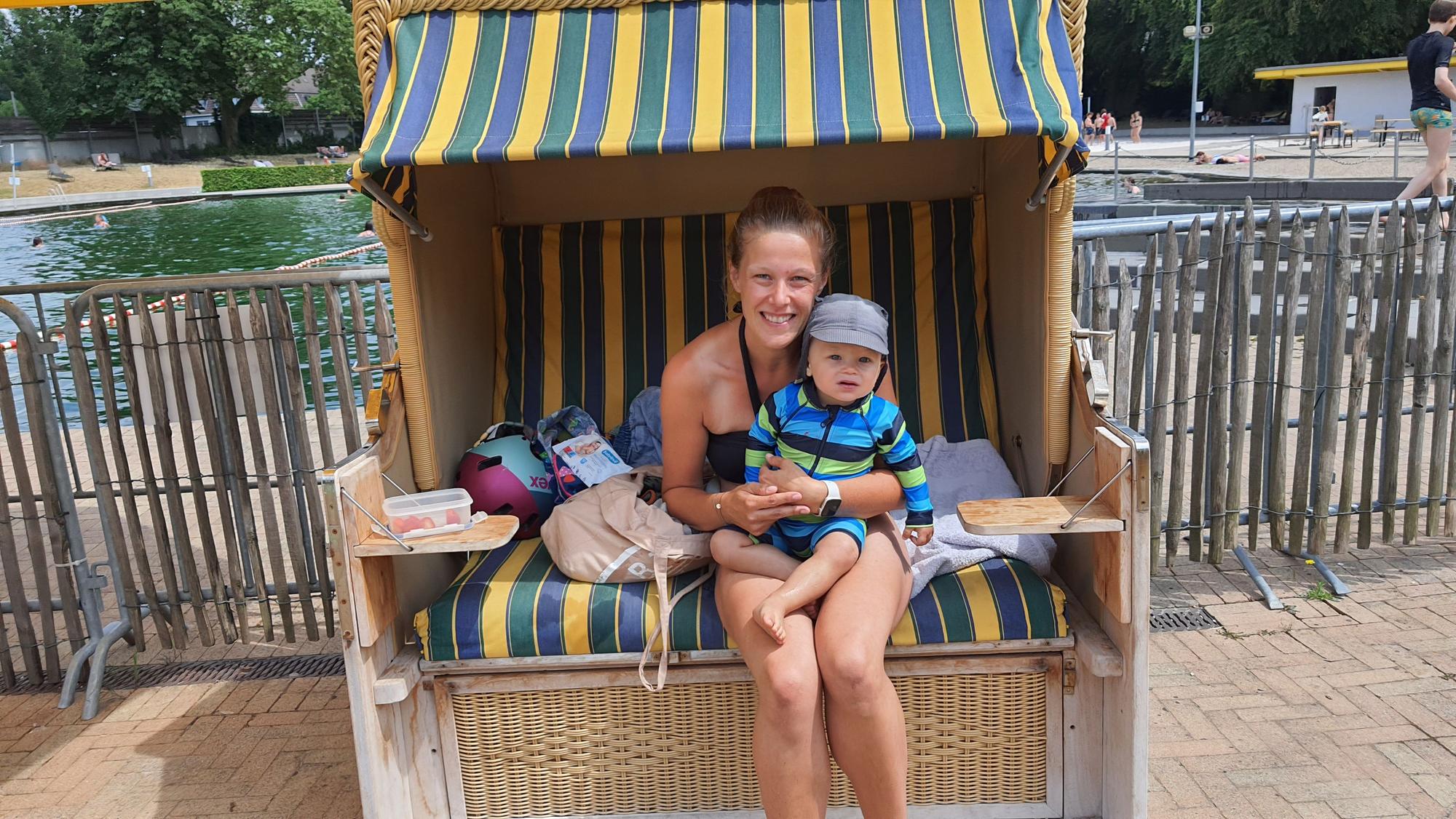 Eine Mutter und ihr Sohn sitzen im Strandkorb vor dem Schwimmbecken.