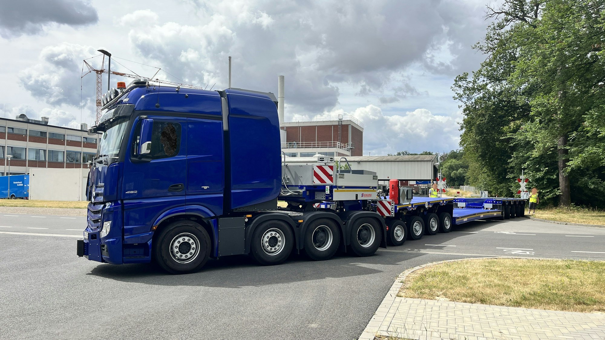 Ein großer blauer Lkw mit großem Anhänger rangiert.