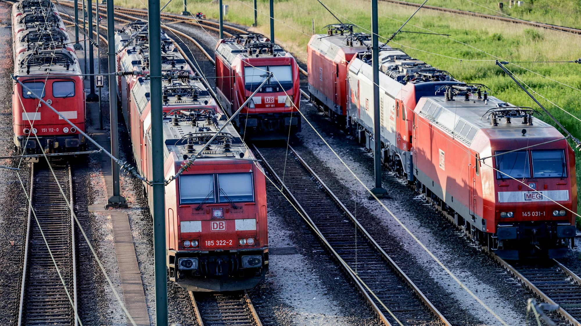 Lokomotiven stehen aufgereiht auf den Gleisen eines Rangierbahnhofs.