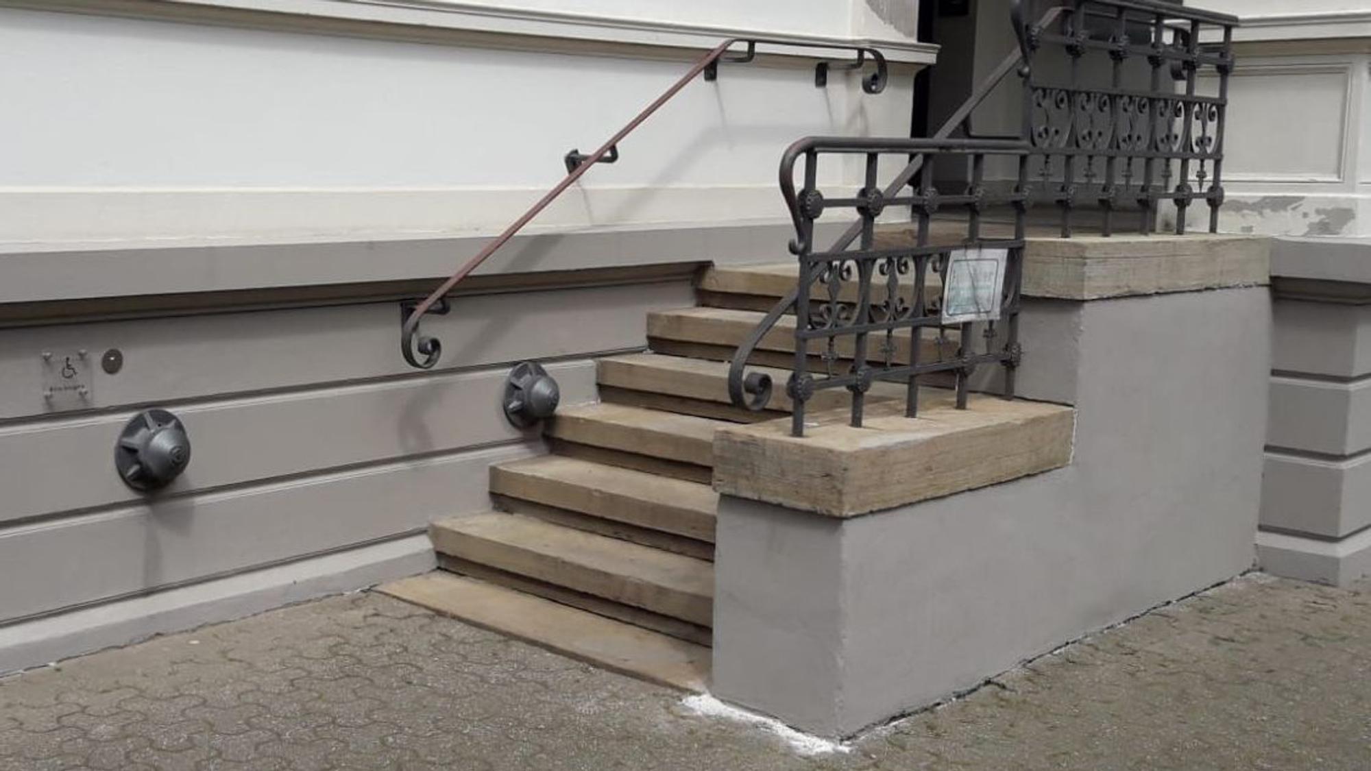 Neuer Putz und frische graue Farbe am Treppenaufgang.