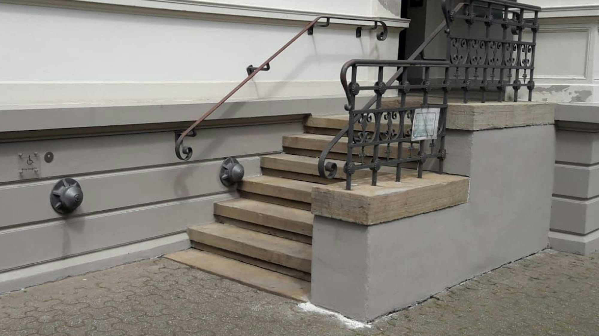 Neuer Putz und frische graue Farbe am Treppenaufgang.