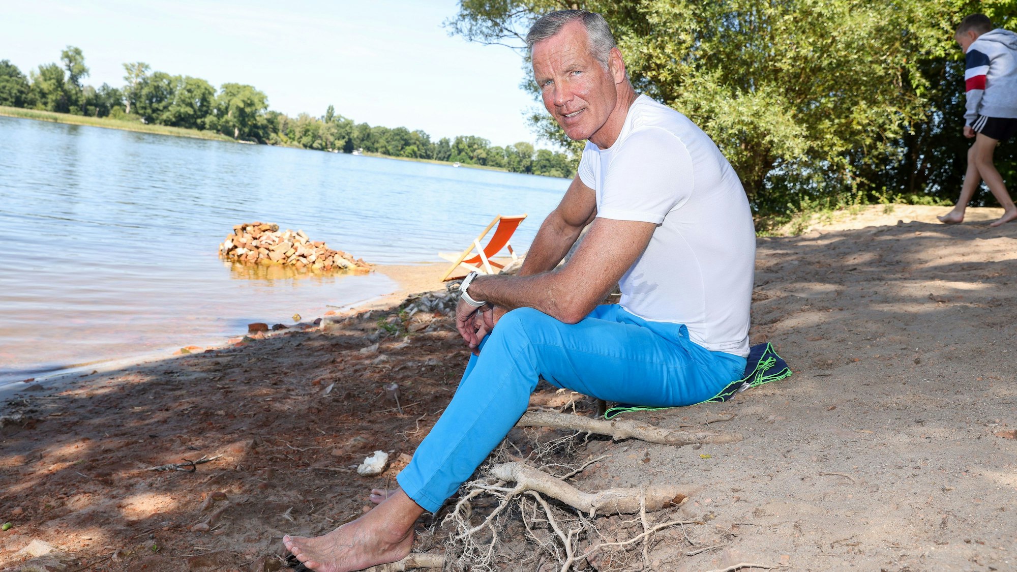Henry Maske sitzt am Strand.