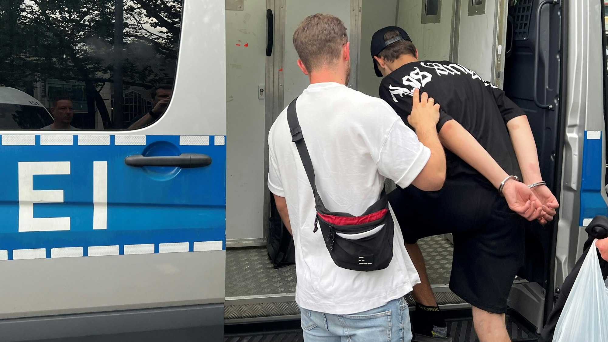 Ein Zivilfahnder der Polizei Köln setzt einen mutmaßlichen Ladendieb auf dem Neumarkt in einen Gefangenentransporter der Polizei.