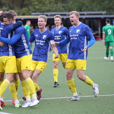 Fußballspieler jubeln nach einem Tor.