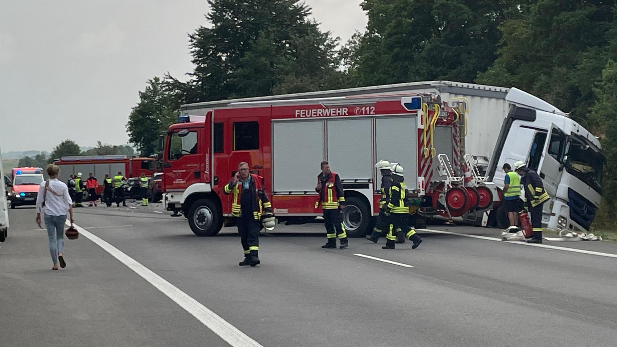 Ein Lkw liegt im Graben. Einsatzkräfte der Feuerwehr sind mit Rettungsarbeiten beschäftigt und sichern die Einsatzstelle.
