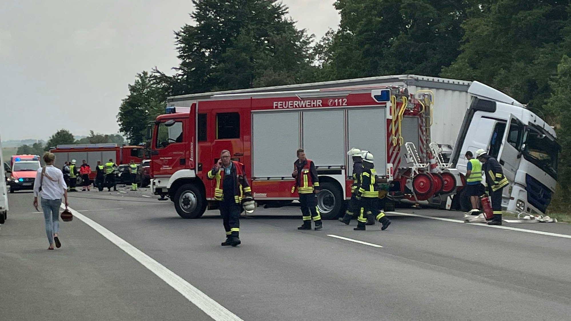 Ein Lkw liegt im Graben. Einsatzkräfte der Feuerwehr sind mit Rettungsarbeiten beschäftigt und sichern die Einsatzstelle.