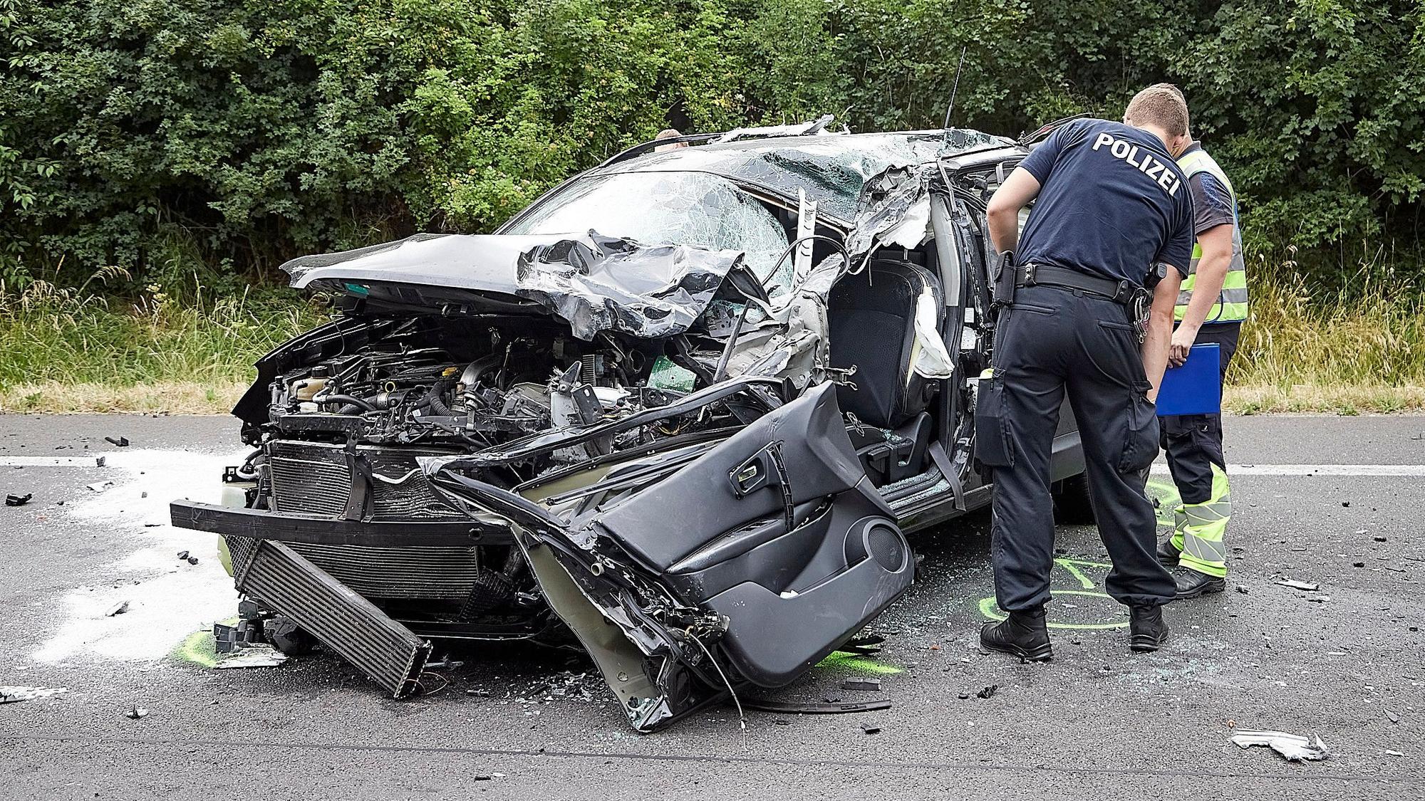 Die Polizei untersucht das Wrack des Autos.