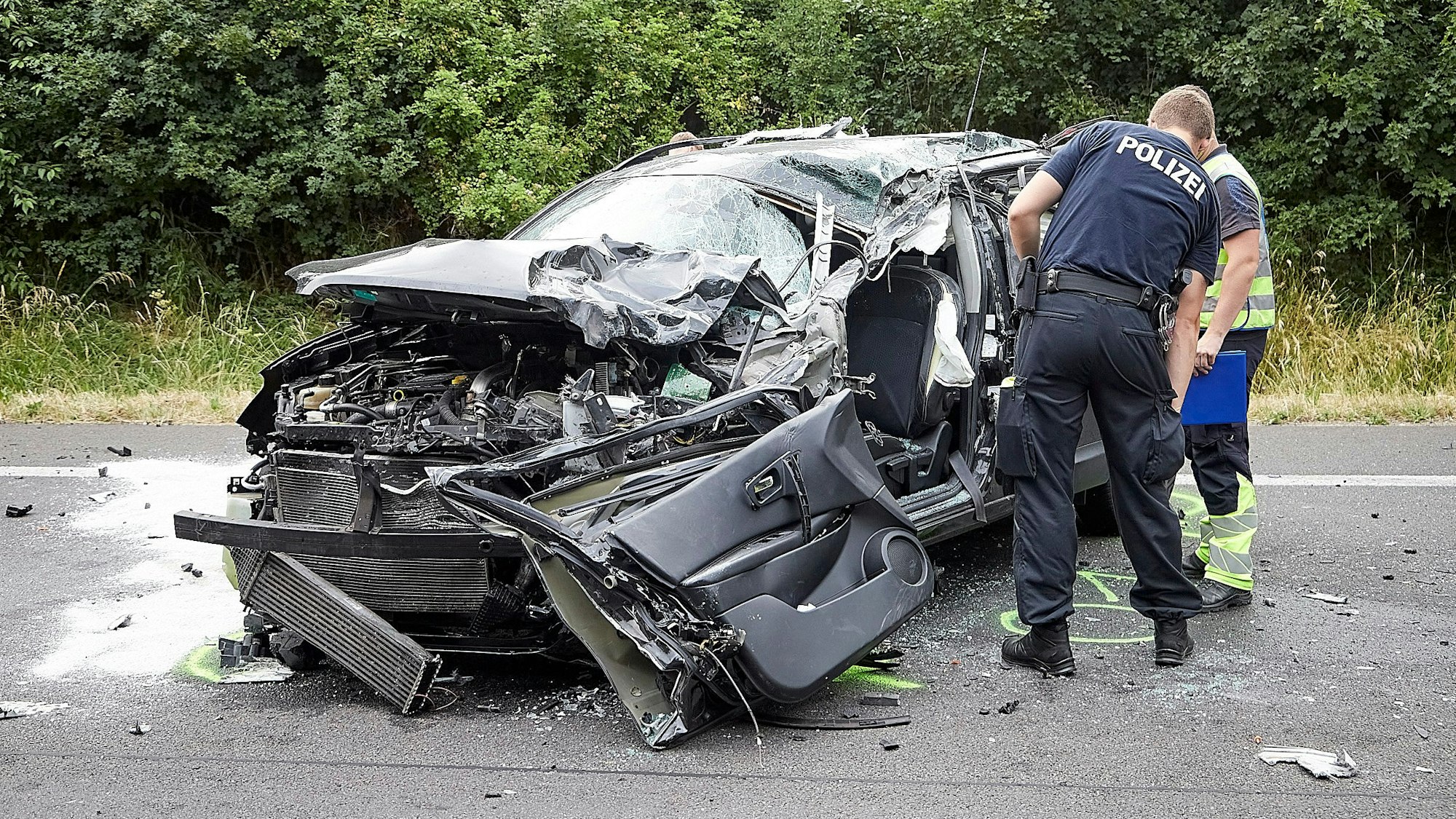 Die Polizei untersucht das Wrack des Autos.