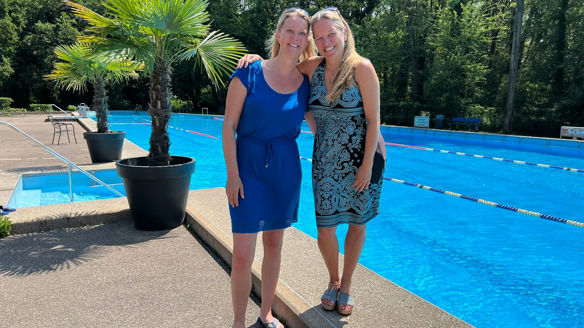 Zwei Frauen posieren vor dem Schwimmerbecken des Waldbades.