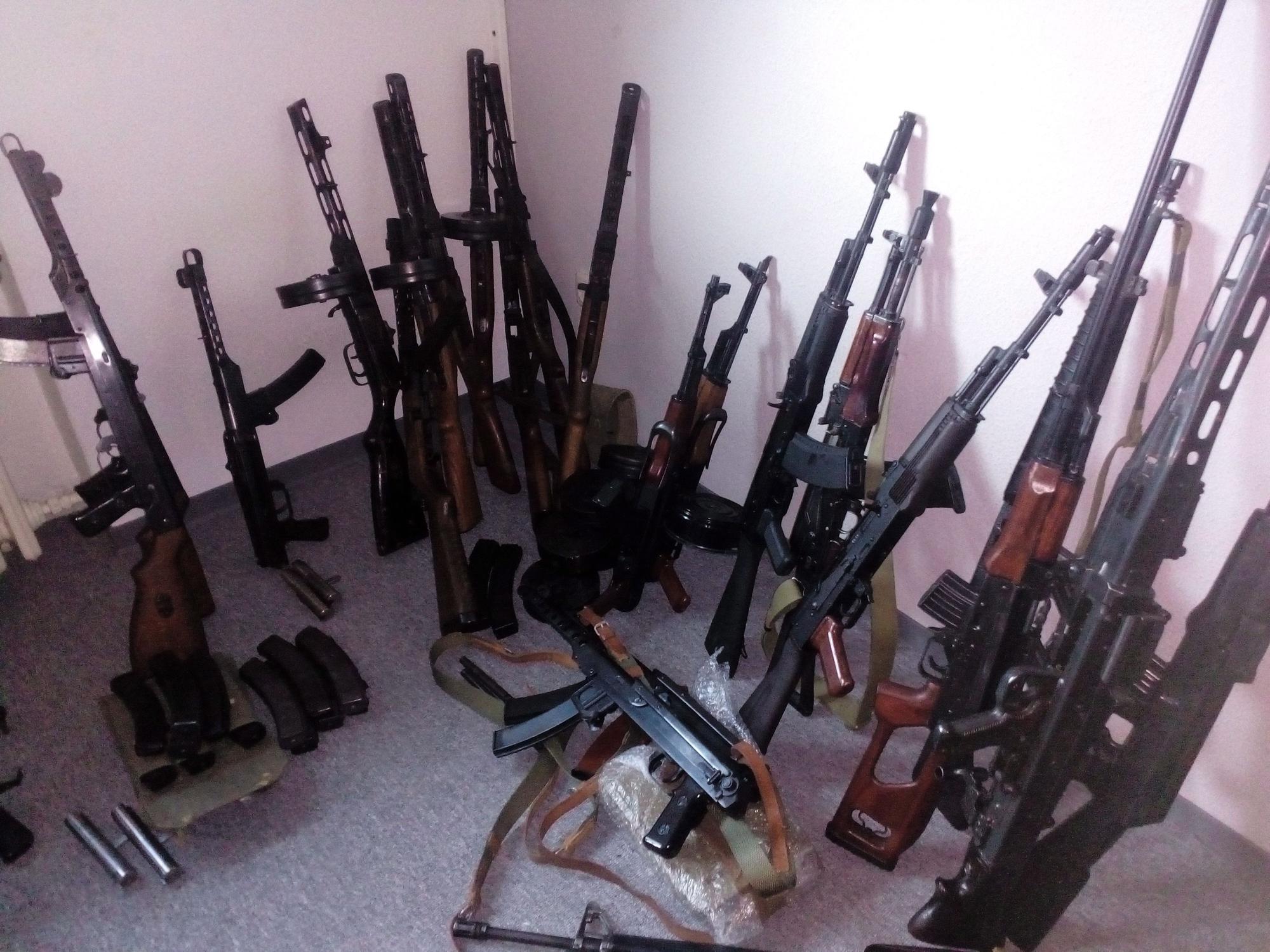 Mehrere Waffen stehen an eine Wand gelehnt.