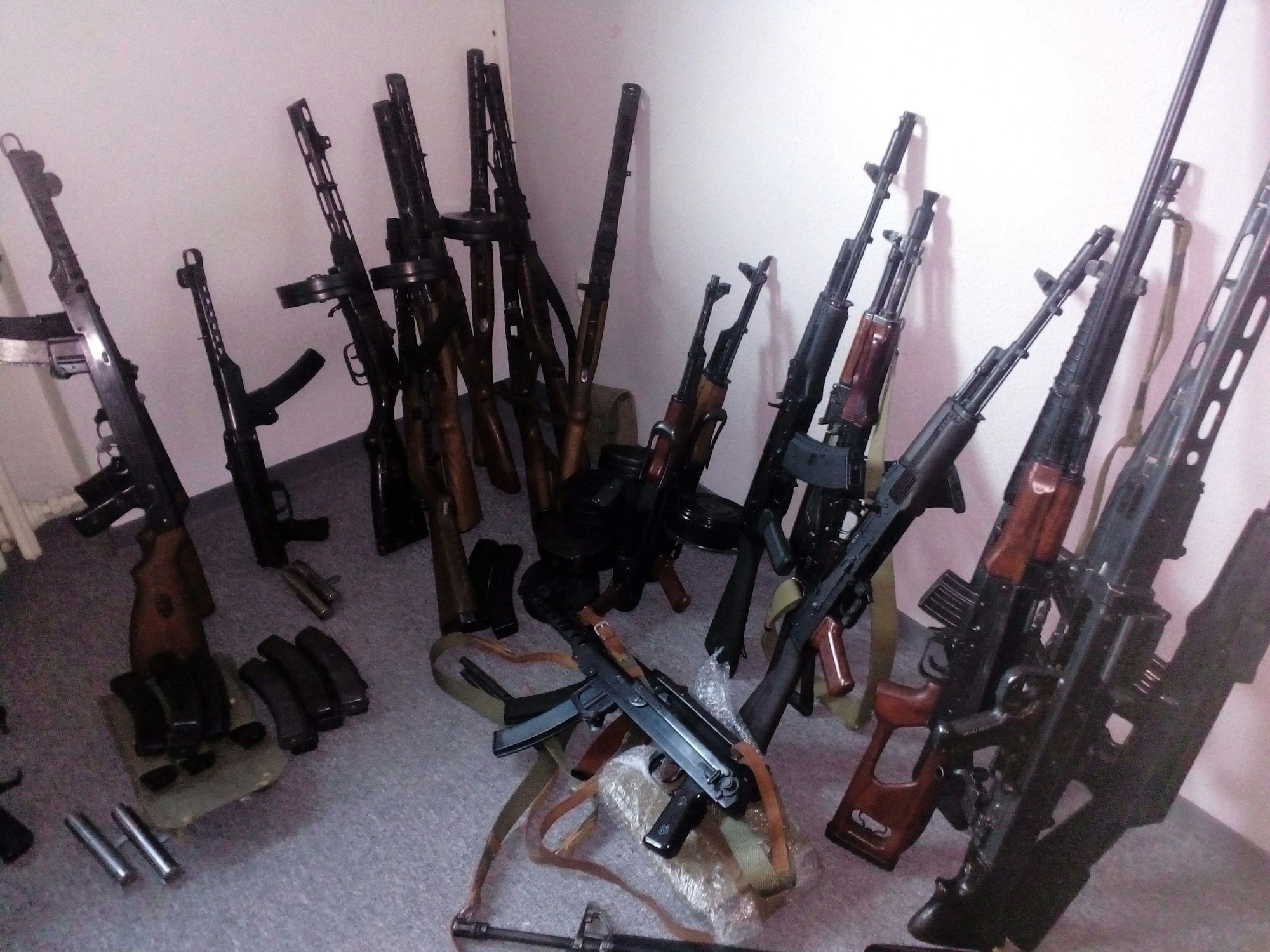 Mehrere Waffen stehen an eine Wand gelehnt.