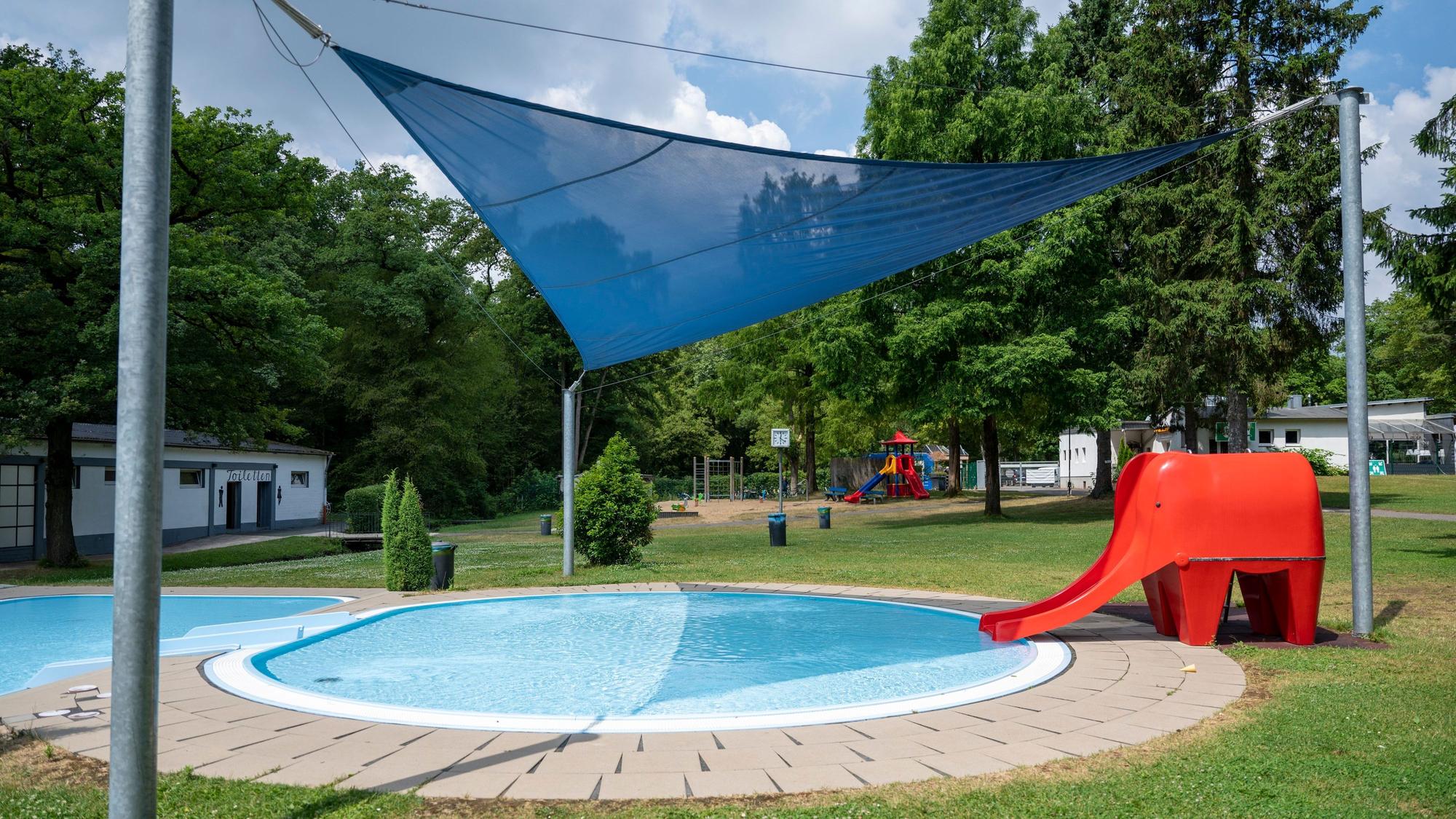 Im Waldbad ist ein Kinderbecken mit einem Segeltuch und eine Elefantenrutsche.