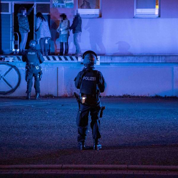 Zivilpolizisten verhaften bei der Razzia in einer ehemaligen Molkerei in Euskirchen-Kuchenheim zwei Frauen, die dort in der Cannabis-Plantage gearbeitet haben. Zwei bewaffnete SEK-Beamte sichern die Rampe der Lagerhalle.