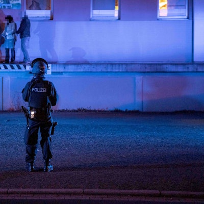 Zivilpolizisten verhaften bei der Razzia in einer ehemaligen Molkerei in Euskirchen-Kuchenheim zwei Frauen, die dort in der Cannabis-Plantage gearbeitet haben. Zwei bewaffnete SEK-Beamte sichern die Rampe der Lagerhalle.