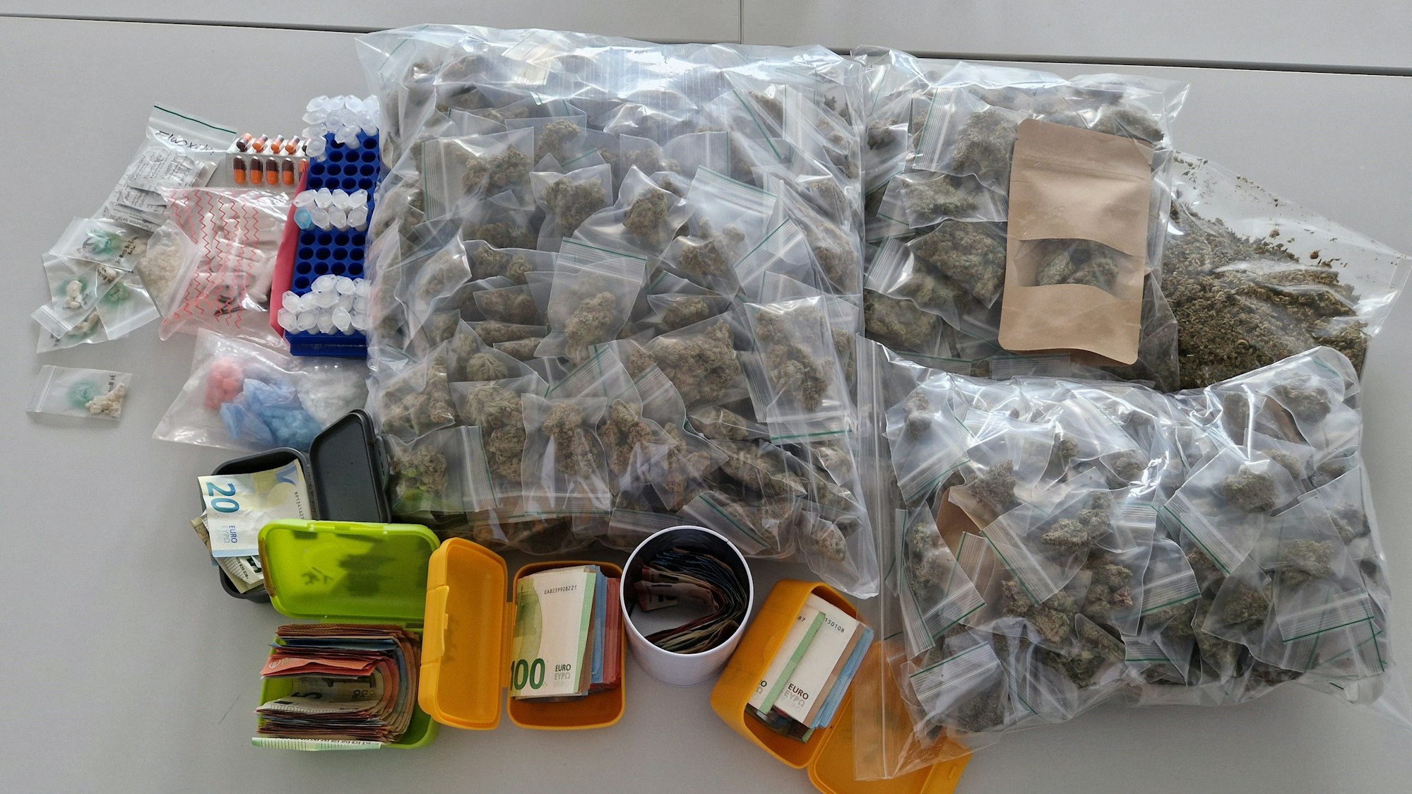 Drogen, Geld und Verpackungsmaterial liegen auf einem Tisch.