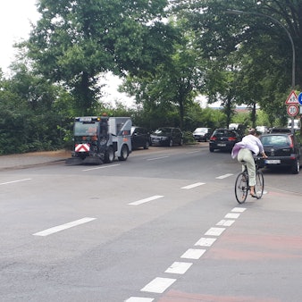 Ein Radfahrer wechselt von der Straße auf den Radfahrstreifen auf dem Gehweg.