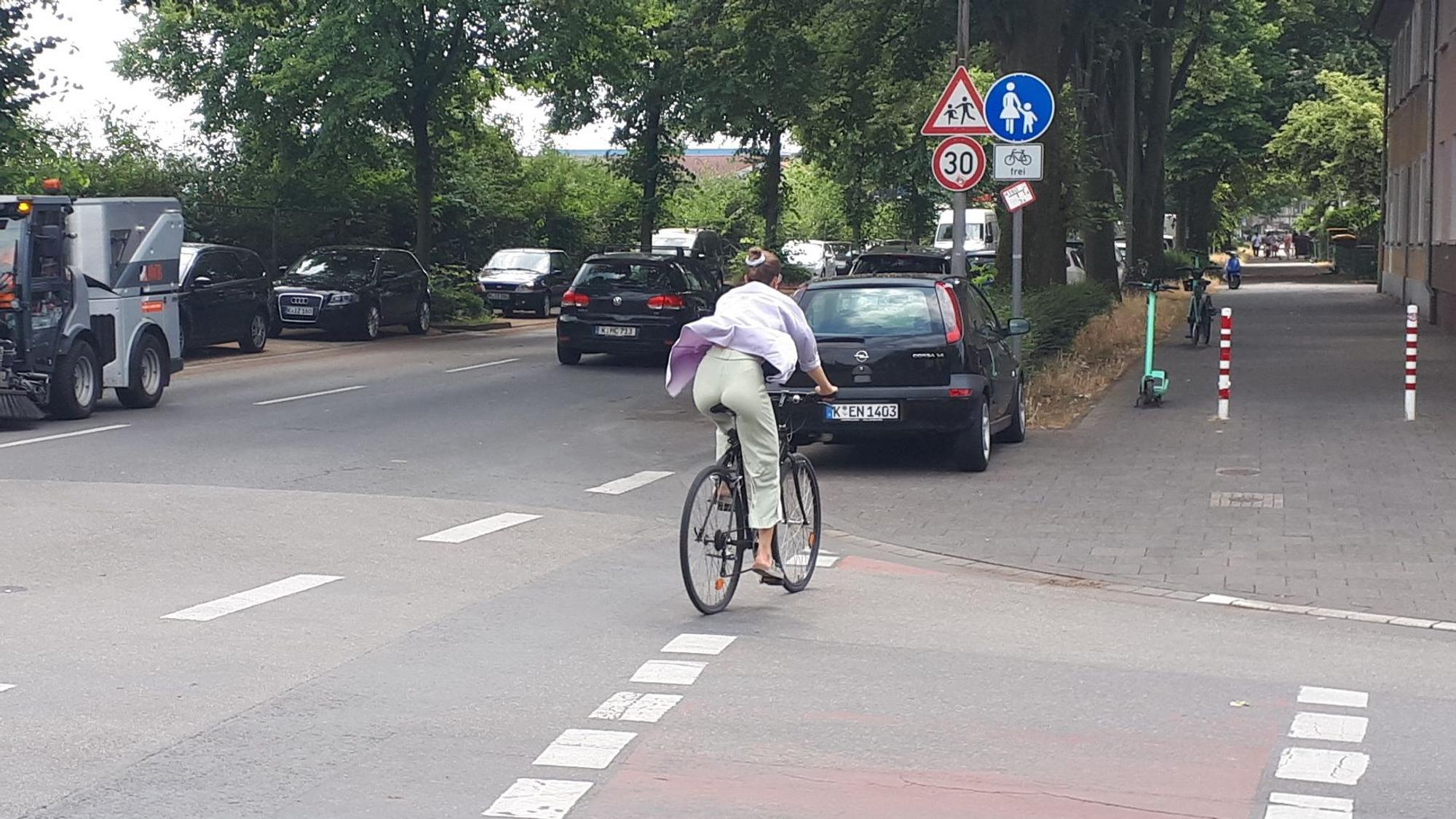 Ein Radfahrer wechselt von der Straße auf den Radfahrstreifen auf dem Gehweg.