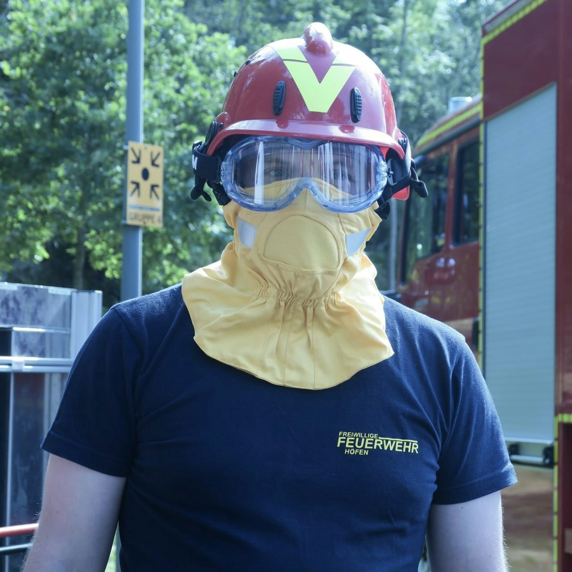Ein Feuerwehrmann trägt die Schutzbekleidung für den Kopf.