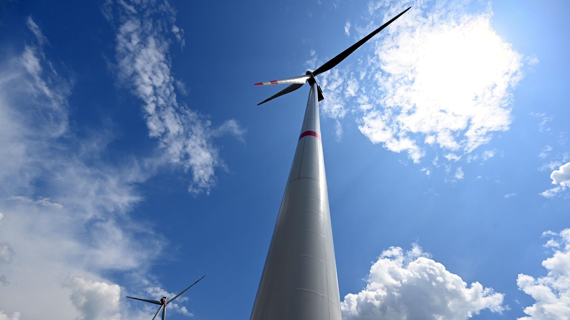 Wolken ziehen über Windräder zur Stromerzeugung.