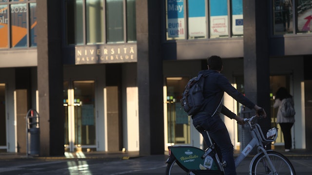 Ein Student fährt mit einem Leihrad der KVB zur Uni.