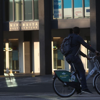 Ein Student fährt mit einem Leihrad der KVB zur Uni.